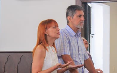 Um casal orando juntos dentro da igreja