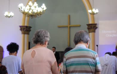 Foto dos fieis dentro da igreja em momento de oração