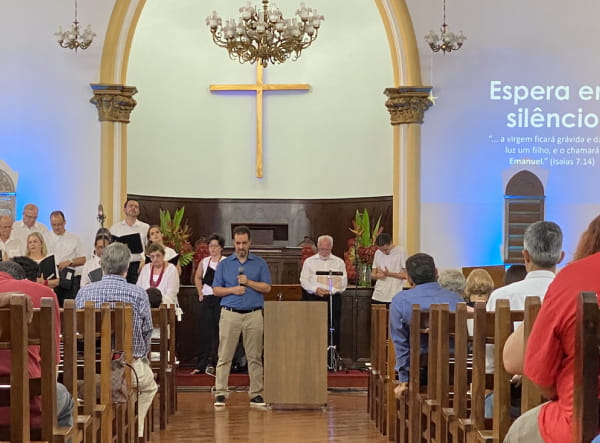 Pastor em cima do altar com o grupo de musica em orações