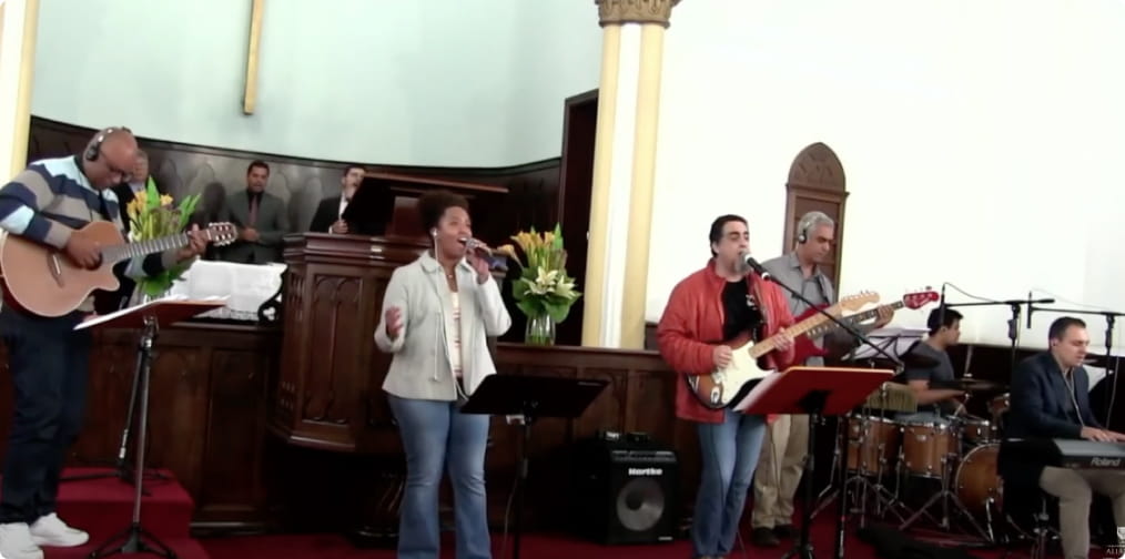 Grupo de louvor cantando e tocando musica em cima do altar
